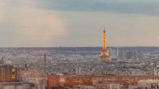 Panorama of Paris city, visible eiffel tower and close surroundings. Early evening setting in summer, tower lit by yellow lights.