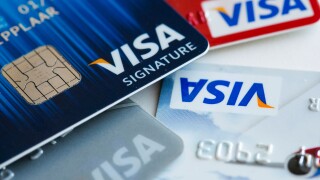 A Visa credit card featuring an EMV chip, also known as "chip and PIN" juxtaposed with a magnetic strip card.