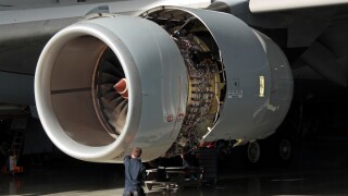 A technician carries out maintenance on a Rolls-Royce Trent 500 aircraft jet engine. Aviation engineering, knowledge workers, skilled workforce.