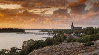 A dramatic colorful sunset in Naantali, Finland with the church and archipelago, sea and Moomin island