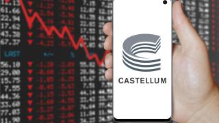 A man holds a smartphone displaying the logo of company Castellum listed on OMX Stockholm. Negative stock market background. Credit: PIXDUCE