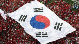 South Korean soccer fans carry a huge national flag as they gather to watch a live TV broadcast of the 2006 World Cup Group G soccer match in Germany between South Korea and Togo on a giant video screen installed outside the Seoul City Hall in Seoul, Sout