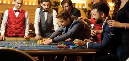 A group of people playing gambling in a casino.