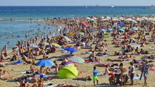 Crowded Barceloneta beach, hot summer day in Barcelona Spain.