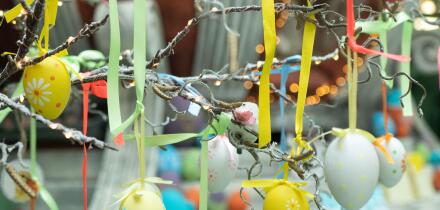 Decoration for Easter holiday celebration, selective focus. Eggs with ornament suspended in ribbons