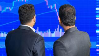 Two stock market trader looks at screen shows candlesticks chart graphic going down, Financial market Crash. Crypto and forex trading.