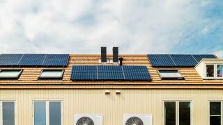 Row of new Dutch houses with solar panels and air-source heat pumps