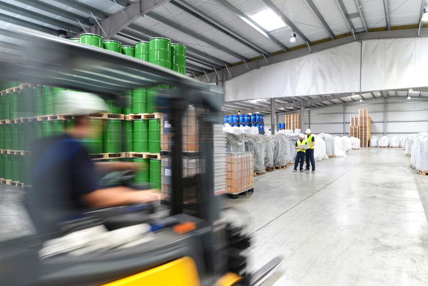 group of workers in the logistics industry work in a warehouse with chemicals