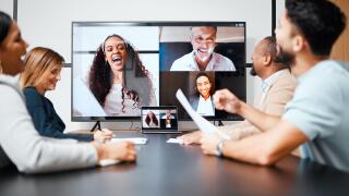 Staying connected with colleagues around the world. a diverse group of businesspeople sitting in the boardroom during a meeting with their international colleagues via video chat.