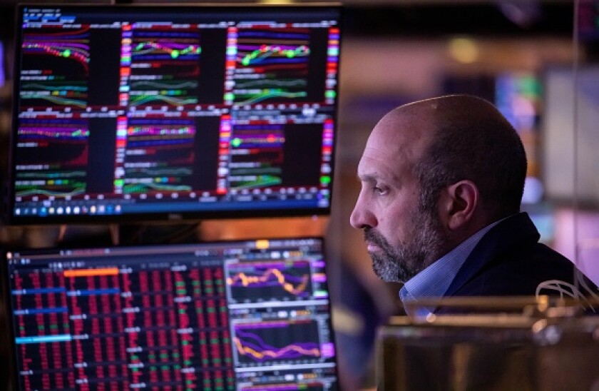 New York, USA. 30th Nov, 2021. A trader works on the trading floor of the New York Stock Exchange (NYSE) in New York, the United States, Nov. 30, 2021. U.S. stocks ended lower on Tuesday as market sentiment was dampened by concerns over COVID-19 variant O