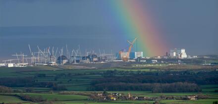 A strong rainbow seeming to emanate from the ?Hinkley C? construction site at Hinkley Point on the Bristol Channel coast, Somerset, England, UK.