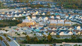 Unfinished frames of inexpensive homes with wooden roof beams under construction. Development of residential housing in US suburbs. Real estate market