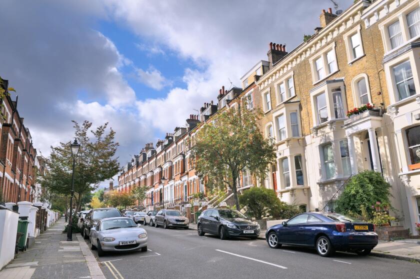 Victorian terraced houses line a residential street with rowan trees in the affluent leafy neighbourhood of Hampstead Village, North London England UK