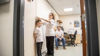 Medical professional measuring a child's height