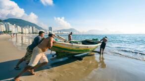 RIO DE JANEIRO - APRIL 4, 2016: Brazilian fishermen launch a brightly painted fishing boat on Copacabana Beach.