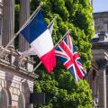French flag and Union Jack flying side by side on flagpoles outside a historic building in Edinburgh, UK. Might depict European travel or allied natio