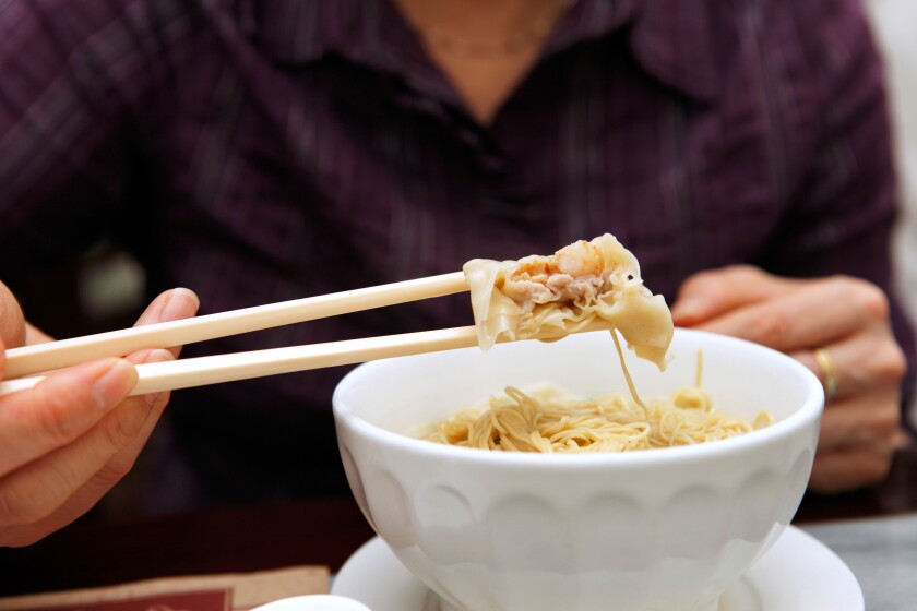 Customer tucks in to pork and shrimp wonton noodle soup served at a restaurant in Macau