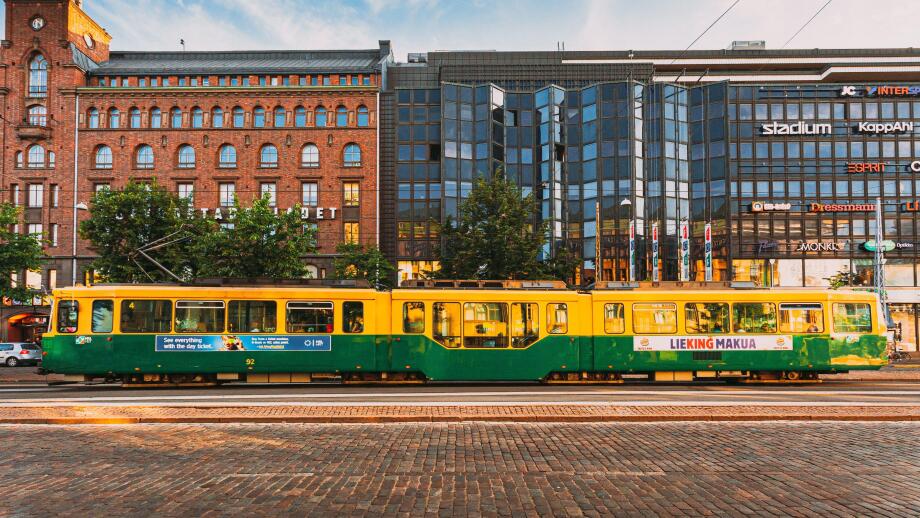 Tram departs from a stop on street Aleksanterinkatu in Helsinki
