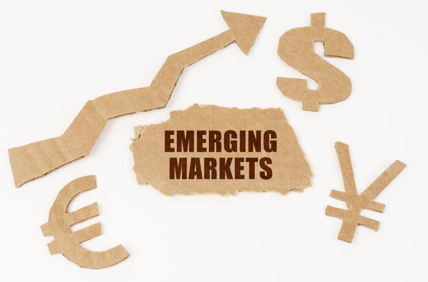 Economic concept. On a white background, symbols of the dollar, euro, yen, an arrow pointing up and a torn cardboard with the inscription - EMERGING M