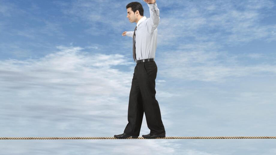 Businessman is balancing on a rope