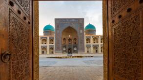 Poi Kalon Madrassa through the carved wooden doors in Bukhara, Uzbekistan.