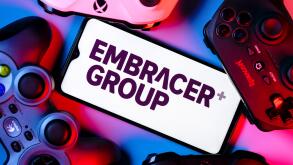 A smartphone with the Embracer Group logo on the screen surrounded by gamepads.