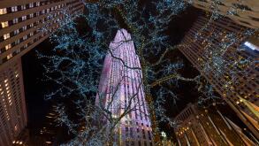 Night view of Rockefeller Center skyscrapers and Plaza illuminated with Winter holiday lights. Manhattan, New York City