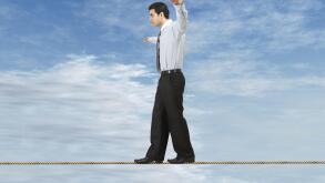 Businessman is balancing on a rope