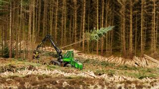 John Deere 1270D Harvester felling timber in a forest in western Scotland.  An example of machinery for harvesting softwood.