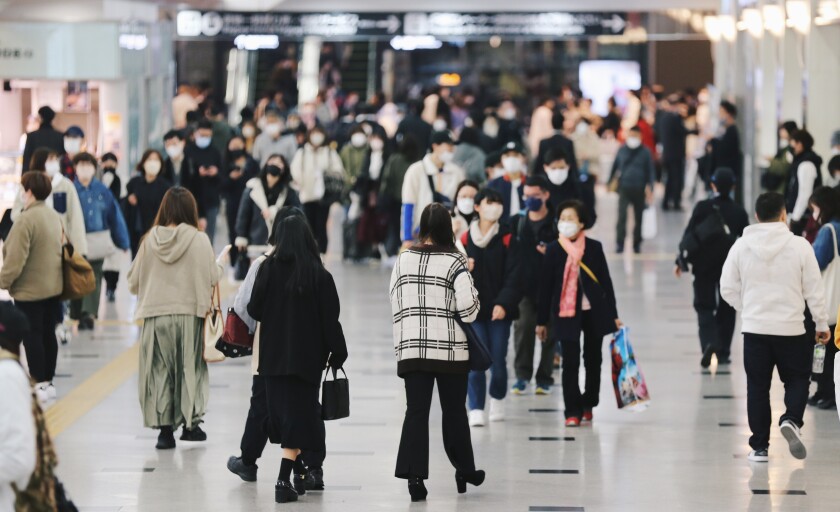 Crowd of people wearing masks walking to work in Osaka, JAPAN (