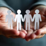 Hands holding paper cutouts of people holding hands. Concept of employee assistance programs support, care. Care for employees well-being, personal issues. Confidential support systems. Crisis