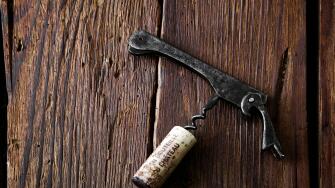 cork and corkscrew on a rustic wooden background