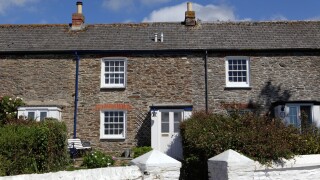 UK housing stock exterior blue sky sunny, fisherman's terraced stone cottages, St. Mawes, Cornwall, UK