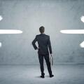 A businessman in doubt, having to shoose between two different choices indicated by arrows pointing in opposite direction concept