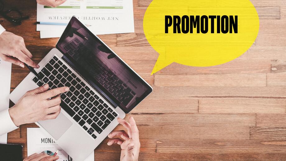 BUSINESS TEAM WORKING IN OFFICE WITH PROMOTION SPEECH BUBBLE ON DESK