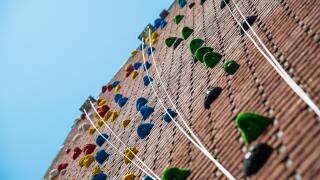 a climbing wall with ropes and blue sky