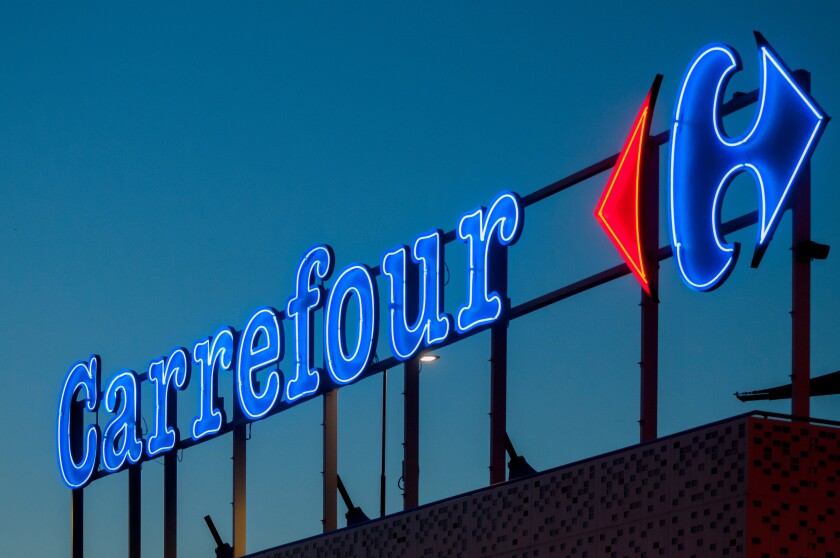 The illuminated neon sign of the French supermarket chain Carref