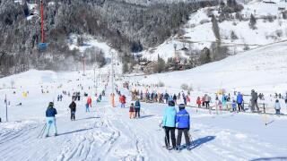 Engelberg, Switzerland - 6 January 2017: people going up with the ski lift and skiing down the slope of Engelberg in the Swiss Alps