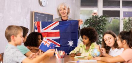 students listen to woman teacher who talks about Australia