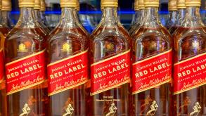 At sea, Atlantic Ocean - 5 January 2025: Close up view of a row of bottles of Johnnie Walker Red Label whisky on sale in a duty free shop.