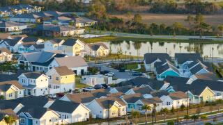 Unfinished frames of inexpensive homes with wooden roof beams under construction. Development of residential housing in US suburbs. Real estate market