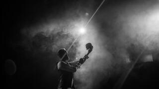 Actor on stage performing Hamlet yorik scene with skull, black and white with spotlight