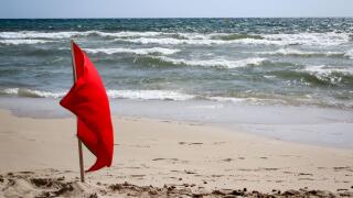 Flags on the beach indicate dangers like jellyfish, undercurrent and other dangers. Image shot 12/2019. Exact date unknown.