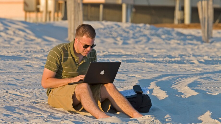 Doing work on computer on the beach