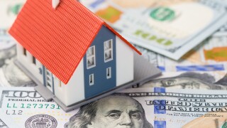 Small house over dollars banknotes. Mortgage concept.