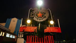 Old black steam locomotive on railway station at night