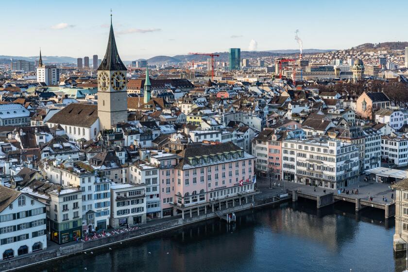 Zurich, Switzerland, Jan. 4, 2026. View of Zurich from Grossmunster tower showing the snowy rooftops, the Limmat river and the St. Peter church
