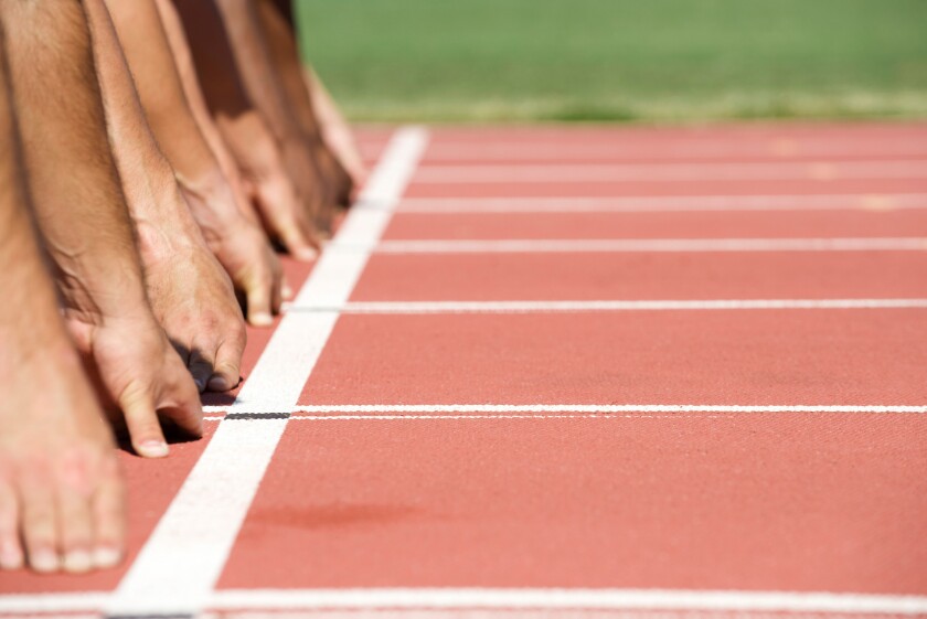 Runners crouched at starting line, cropped