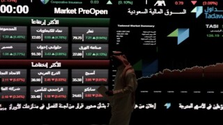A Saudi man walks  at the Tadawul Saudi Stock Exchange, in Riyadh, Saudi Arabia, Monday, June 15, 2015.