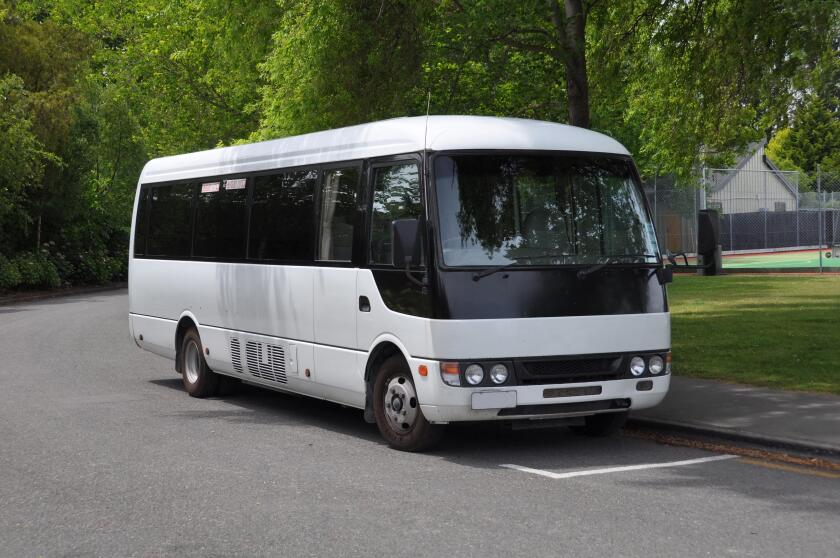 A small white tour coach, bus or mini-van used to transport passengers and tourists. Typically used for small group tours of around 21 passengers.